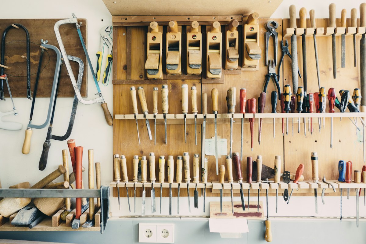 Artisan charpentier dans son atelier façonnant des pièces de bois de bout et assemblages traditionnels